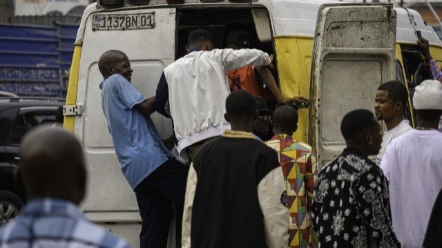 Des navetteurs se bousculent pour monter à bord de minibus-taxis à Kinshasa, le 2 juillet 2024. 