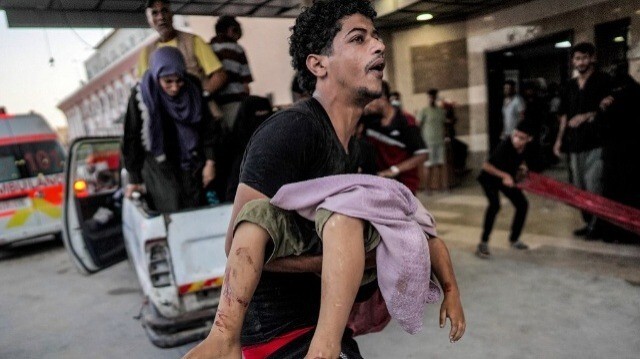 Un homme porte le corps d'un enfant tué par un bombardement israélien à l'extérieur du complexe médical Nasser à Khan Yunis dans le sud de la bande de Gaza le 5 juillet 2024. 