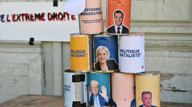 Des affiches des figures du Rassemblement National (RN), dont le président Jordan Bardella (en haut), la présidente du groupe parlementaire Marine Le Pen (au milieu), le fondateur du Front National (FN) Jean-Marie Le Pen (en bas à gauche), et le maire de Perpignan Louis Aliot (en bas à droite), sont vues sur des boîtes utilisées dans un jeu de quille lors d'un rassemblement contre l'extrême droite à la Place Albert 1er à Montpellier le 4 juillet 2024, en amont du second tour des législatives en France.