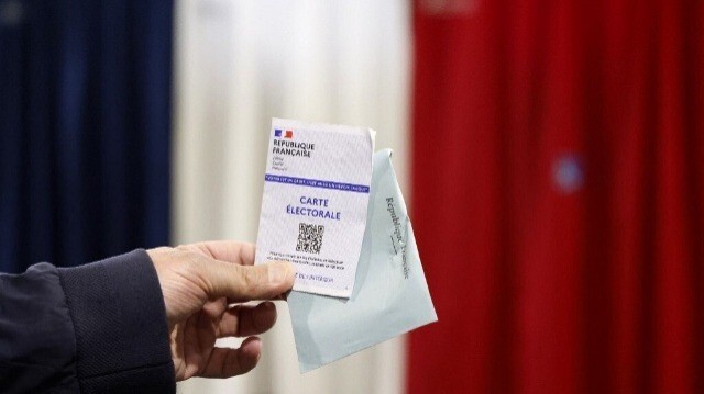 Une carte électorale et un bulletin de vote sont affichés lors du second tour des élections législatives françaises dans un bureau de vote au Touquet, dans le nord de la France, le 7 juillet 2024.