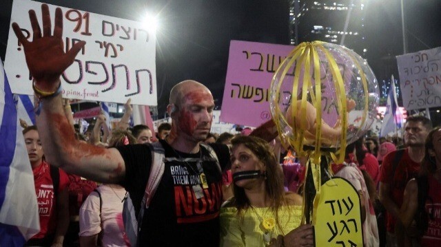 Un homme lève ses mains couvertes de faux sang lors d'une manifestation de supporters et de parents d'Israéliens retenus en otage par des militants palestiniens à Gaza depuis les attaques du 7 octobre, à Tel Aviv le 6 juillet 2024.