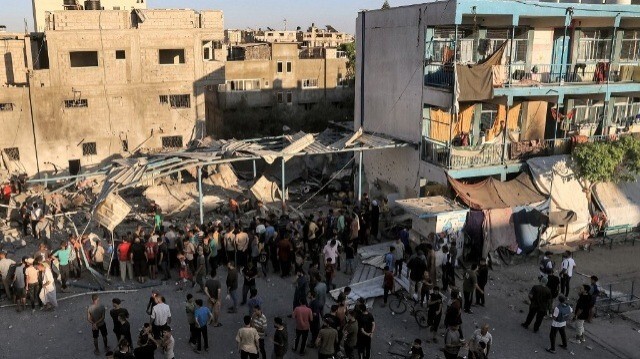 Des personnes se rassemblent pour fouiller les décombres d'un bâtiment effondré à la suite d'un bombardement israélien à l'école Jaouni gérée par l'Office de secours et de travaux des Nations Unies pour les réfugiés de Palestine (UNRWA) à Nuseirat, dans le centre de la bande de Gaza, le 6 juillet 2024.