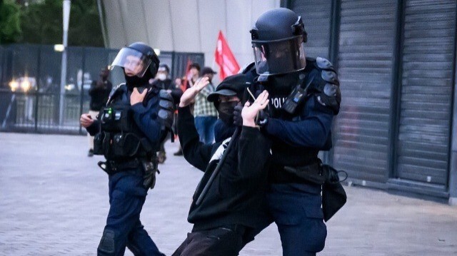 Un policier anti-émeute retient un manifestant lors d'une protestation après l'annonce des premiers résultats du second tour des élections législatives à Nantes, dans l'ouest de la France, le 7 juillet 2024. 