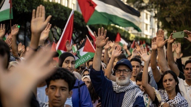 Des personnes agitent des drapeaux nationaux palestiniens et lèvent les mains lors d'une marche de solidarité avec le peuple de Gaza dans la ville de Tanger le 7 juillet 2024.