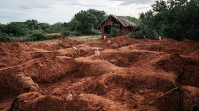 Des trous creusés sont visibles après l'exhumation des corps sur le site de la fosse commune de Shakahola, à l'extérieur de la ville côtière de Malindi, le 25 avril 2023. 