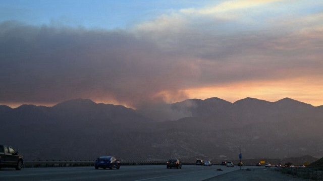Fumée s'élevant au loin alors que le feu brûle dans la forêt nationale de San Bernardino, près d'Oak Hills, Californie, le 7 juillet 2024.