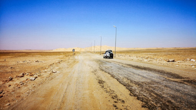 Cette photo prise le 30 mars 2019 montre un véhicule à quatre roues motrices circulant sur une route détériorée dans le désert près de la ville de Ghadames, dans l'extrême ouest de la Libye, à proximité des frontières avec la Tunisie et l'Algérie. 