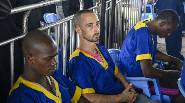 Le ressortissant américain Benyamin Zalman-Polun (C) est assis parmi d'autres accusés d'une tentative de coup d'État ratée à la prison de Ndolo à Kinshasa le 7 juin 2024. 