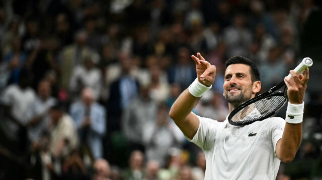 Novak Djokovic fait semblant de jouer du violon pour sa fille en célébrant sa victoire contre le Danois Holger Rune, à Wimbledon, au sud-ouest de Londres, le 8 juillet 2024.  