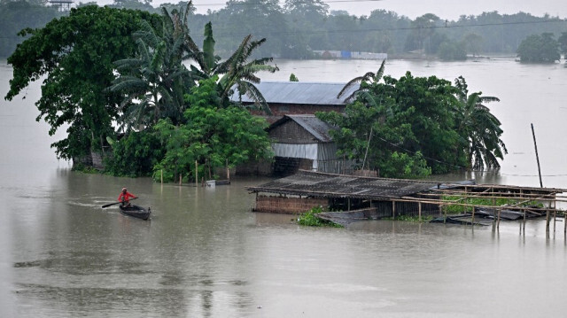 Un homme rame sur un bateau dans une zone touchée par les inondations dans le village de Buraburi dans le district de Morigaon dans l'État indien d'Assam le 5 juillet 2024.