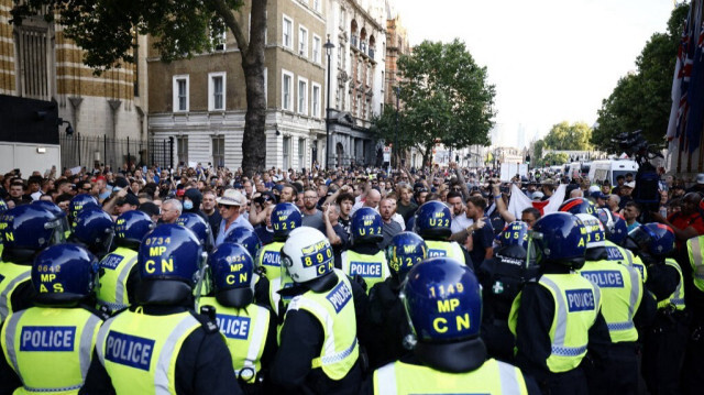 Les policiers encerclent les manifestants lors de la manifestation "Trop c'est trop" à Whitehall, devant l'entrée du 10 Downing Street, au centre de Londres, le 31 juillet 2024.