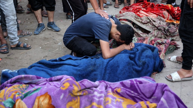 Un jeune homme pleure le corps d'une personne tuée lors d'une frappe israélienne sur une école utilisée par des Palestiniens déplacés comme abri temporaire dans la ville de Gaza le 10 août 2024.