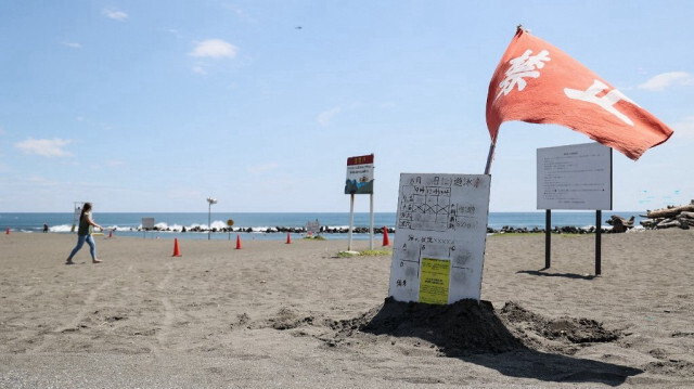 Un drapeau rouge flotte au vent alors que les autorités déconseillent de se baigner au parc de la plage de Shonan Bellmare à Hiratsuka, dans la préfecture de Kanagawa, au sud-ouest de Tokyo, le 10 août 2024, après que la ville a pris des mesures en réponse à l'annonce par le gouvernement d'une "alerte au séisme majeur". 