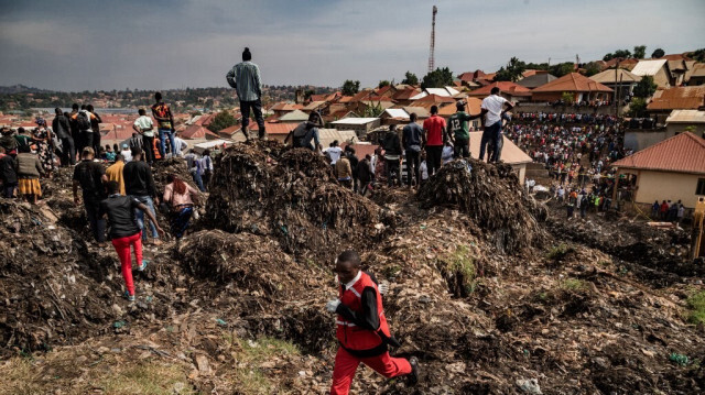 Un agent de la Croix-Rouge court chercher de l'aide après l'effondrement d'une décharge à Kampala, le 10 août 2024. 