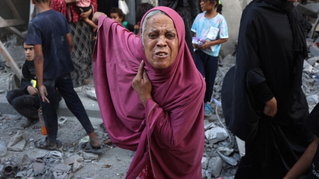 Une femme palestinienne en pleurs tandis que d'autres personnes observent les dégâts après un bombardement israélien dans le quartier Sheikh Radwan de Gaza City, le 11 août 2024.






