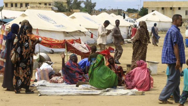 Des Soudanais déjà déplacés par le conflit marchent près de tentes dans un campement de fortune où ils ont été évacués, dans la ville orientale de Kassala, le 12 août 2024.  