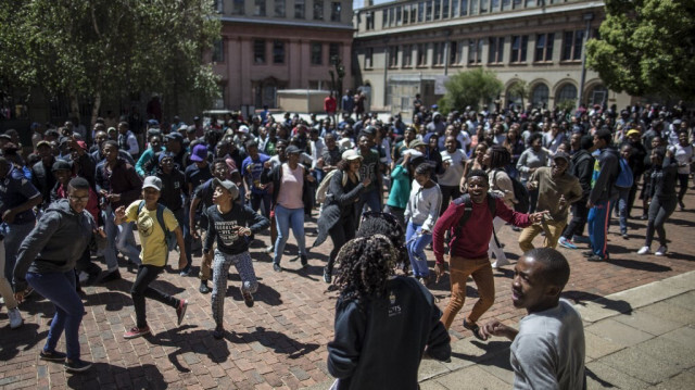 Des étudiants de l'Université de Witwatersrand à Johannesburg dansent lors d'une manifestation sur le campus le 3 octobre 2016 se déplaçant de bâtiment en bâtiment pour suspendre les activités de l'université pour la journée. 