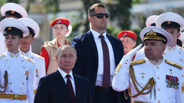 Le président russe Vladimir Poutine (G) et le commandant en chef de la marine russe, l'amiral Alexander Moiseyev (D), assistent à la principale parade navale marquant la Journée de la marine russe à Saint-Pétersbourg, le 28 juillet 2024. 