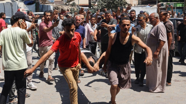 Des Palestiniens transportent des personnes blessées par des bombardements israéliens vers l'hôpital des Martyrs d'Al-Aqsa à Deir el-Balah, dans le centre de la bande de Gaza, le 13 août 2024.