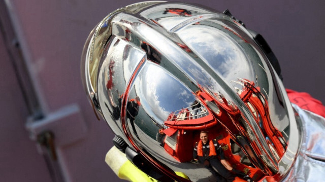 Des membres du Bataillon des marins-pompiers de Marseille se reflètent sur un casque lors d'un exercice d'incendie à bord d'un navire dans le port de Marseille, le 17 octobre 2023.