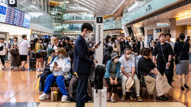 Des voyageurs dans le hall des départs de l'aéroport Haneda de Tokyo.