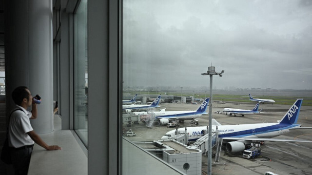 Les avions de passagers de la compagnie All Nippon Airways (ANA) sont vus depuis la zone d'observation de l'aéroport Haneda de Tokyo, le 16 août 2024, alors que le typhon Ampil se dirige vers la capitale du Japon.