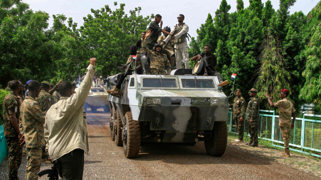 Des personnes acclament des membres des forces armées soudanaises lors d'un défilé militaire organisé à l'occasion de la Journée de l'armée à Gadaref, le 14 août 2024.