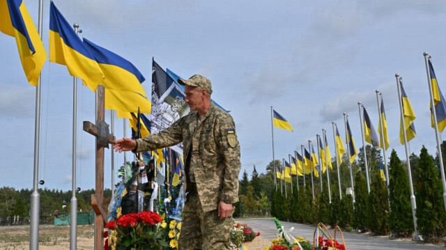 Un militaire ukrainien rend hommage à son ami Spartak Yarkin, tué par un tireur d'élite russe à Bucha en mars 2022, lors d'une cérémonie de réinhumation dans l'allée des héros de la ville d'Irpin, près de Kiev, le 5 octobre 2023, dans le contexte de l'invasion russe en Ukraine. 