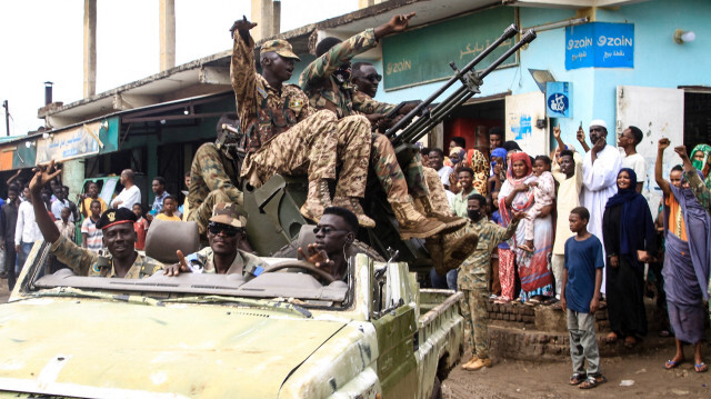 Des personnes acclament des membres des forces armées soudanaises lors d'un défilé militaire organisé à l'occasion de la Journée de l'armée à Gadaref, le 14 août 2024.