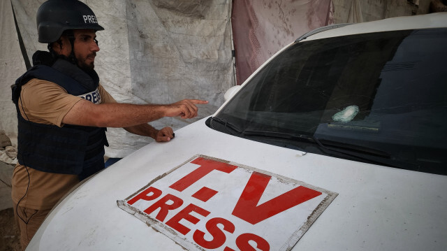 Sami Barhoum, journaliste de TRT Arabi, montre la vitre de sa voiture endommagée par une attaque israélienne à Khan Younès dans la Bande de Gaza, le 18 août 2024.