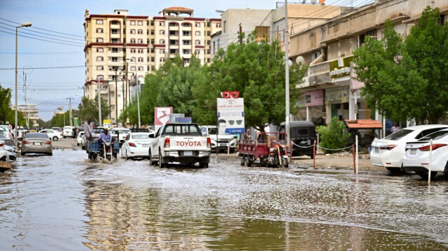 Des voitures circulent dans une rue inondée de Port Soudan après des pluies torrentielles, le 1er août 2024. 