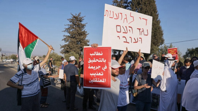 Des Arabes israéliens manifestant avec des pancartes "nous demandons une enquête sur le crime de torture des prisonniers"  devant la prison de Megiddo, dans le nord d'Israël, le 22 août 2021.