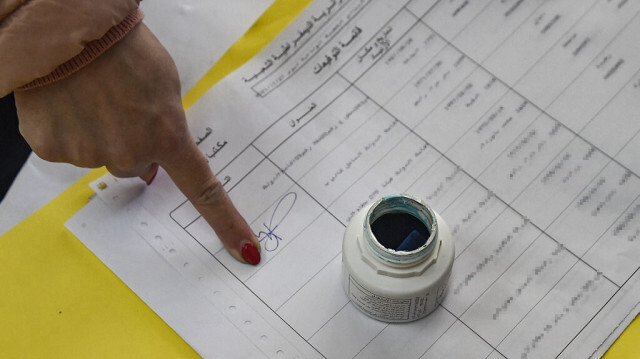 Une femme signe un registre après avoir voté aux élections locales algériennes dans un bureau de vote, à Alger, la capitale, le 27 novembre 2021. 