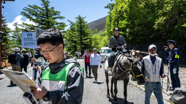 Un touriste monte à cheval près de la 5e station de la ligne Fuji Subaru, qui mène au sentier Yoshida, très prisé des randonneurs qui gravissent le mont Fuji, avant sa réouverture pour la saison à Narusawa, dans la préfecture de Yamanashi.