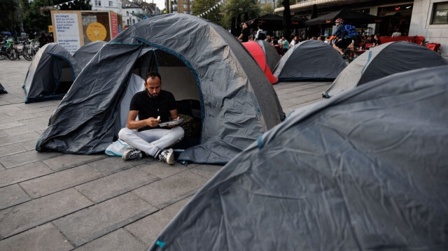 Demandeur d'asile mangeant dans sa tente à Bruxelles, le 15 septembre 2023.