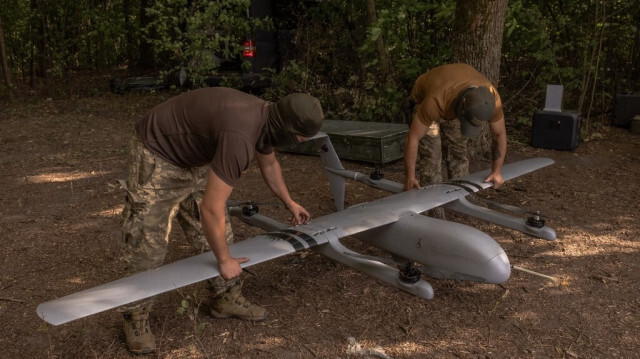 Des opérateurs militaires ukrainiens de la 22e brigade mécanisée assemblent un drone Poseidon à leur poste, dans la région de Sumy, près de la frontière avec la Russie, le 11 août 2024.