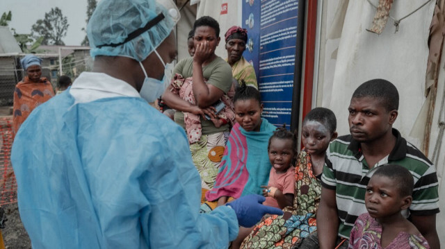 Des patients écoutent un médecin à l'extérieur de la salle de consultation du centre de traitement de la variole à l'hôpital général de référence de Nyiragongo, au nord de Goma, le 17 août 2024. 