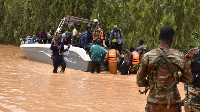 Cette photographie prise le 20 août 2024 montre des bateaux de police utilisés pour transporter des personnes suite aux fortes pluies qui ont endommagé la route nationale 25 reliant la capitale nigérienne Niamey aux provinces de Tillabéri et Tahoua dans l'ouest du Niger. 