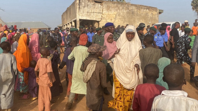 Des membres des forces de sécurité nigérianes regardent des enfants libérés après avoir été enlevés par des hommes armés à Kuriga, qui retrouvent leur famille à Kuriga, le 28 mars 2024. 