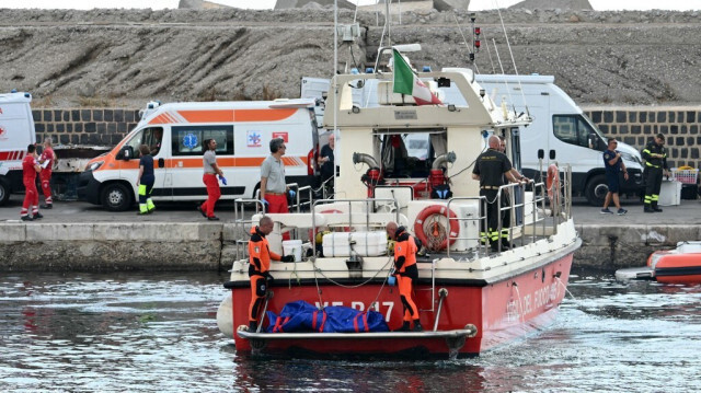 Les plongeurs des Vigili del Fuoco, arrivent dans le port de Porticello, près de Palerme, avec le corps de Mike Lynch à l'arrière du bateau, le 22 août 2024, trois jours après le naufrage du yacht de luxe Bayesian, battant pavillon britannique. 