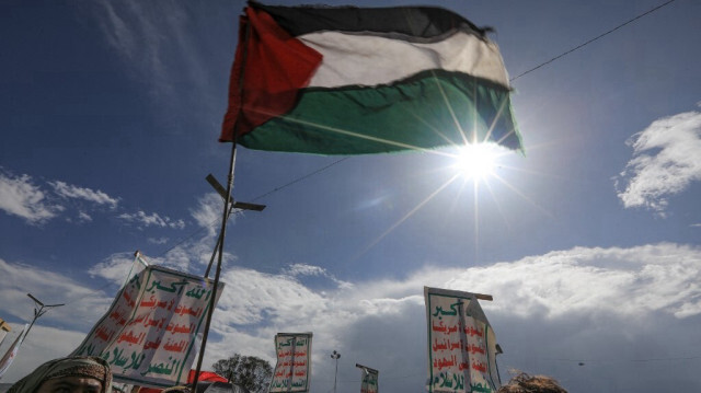 Des Yéménites brandissent des pancartes et un drapeau palestinien lors d'un rassemblement de soutien aux Palestiniens, dans la capitale Sanaa, contrôlée par les Huthis, le 23 août 2024.