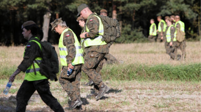 Des militaires polonais ratissant les champs dans les environs de Tyszowce, en Pologne, afin de trouver les débris de l'objet russe non identifié ayant pénétré le territoire polonais, le 27 août 2024.