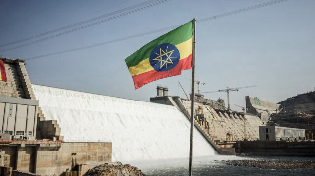 Cette vue générale montre un drapeau national éthiopien flottant devant le Grand Ethiopian Renaissance Dam (GERD) à Guba, en Éthiopie, le 19 février 2022. 