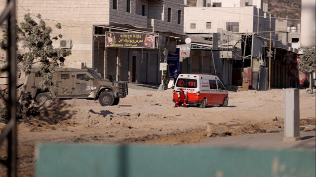 Un véhicule médical attend sur le bord d'une route alors que les forces israéliennes n'ont pas donné l'autorisation d'entrer dans la zone après avoir organisé un raid sur le camp de réfugiés de Nur Shams à Tulkarem, en Palestine occupée.