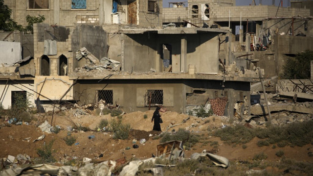 Une femme passe devant les décombres des bâtiments détruits par les bombardements israéliens, près du camp de réfugiés palestiniens d'al-Maghazi, dans le centre de la bande de Gaza, le 2 août 2024.