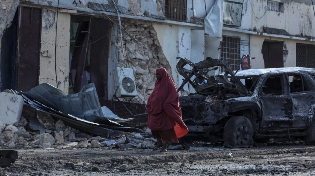 Une femme passe devant les débris et la destruction d'un café à Mogadiscio le 15 juillet 2024 suite à l'explosion d'une voiture piégée où cinq personnes ont été tuées le 14 juillet 2024.