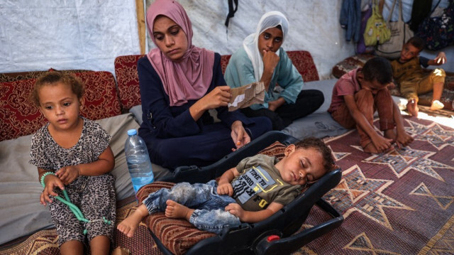 Le 27 août 2024, le jeune Palestinien Abdel Rahman Abu al-Jedian, atteint de polio depuis un mois, dort entouré de sa famille dans leur tente à Deir al-Balah, au centre de la bande de Gaza.