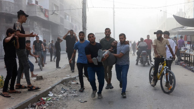 Des Palestiniens évacuent un blessé après un bombardement israélien qui a touché un complexe scolaire, comprenant les écoles Hamama et al-Huda, dans le quartier de Sheikh Radwan, au nord de la ville de Gaza, le 3 août 2024.