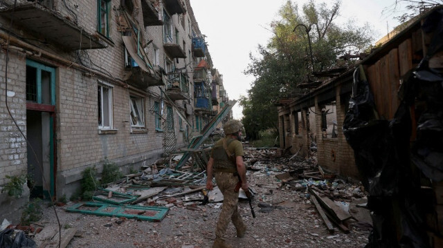 Un soldat ukrainien du 225e bataillon d'assaut séparé patrouille devant des bâtiments lourdement endommagés par des tirs d'artillerie dans la ville de Chasiv Yar, dans la région de Donetsk, le 24 juillet 2024.