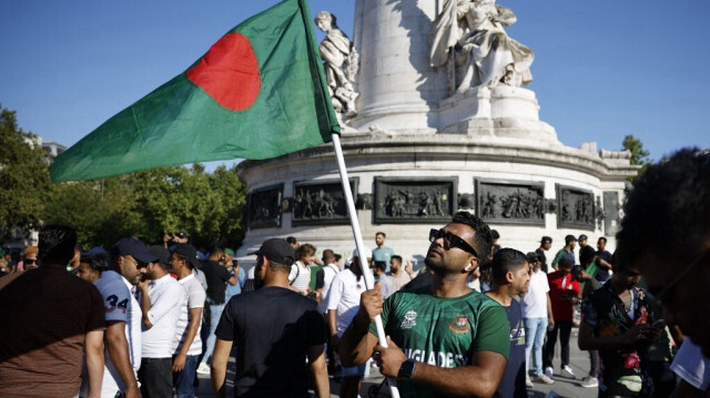 Un manifestant brandit le drapeau national du Bangladesh sur la place de la République, en soutien aux manifestations anti-gouvernementales au Bangladesh, après le renversement de la Première ministre bangladaise, Sheikh Hasina, à Paris, le 5 août 2024. 